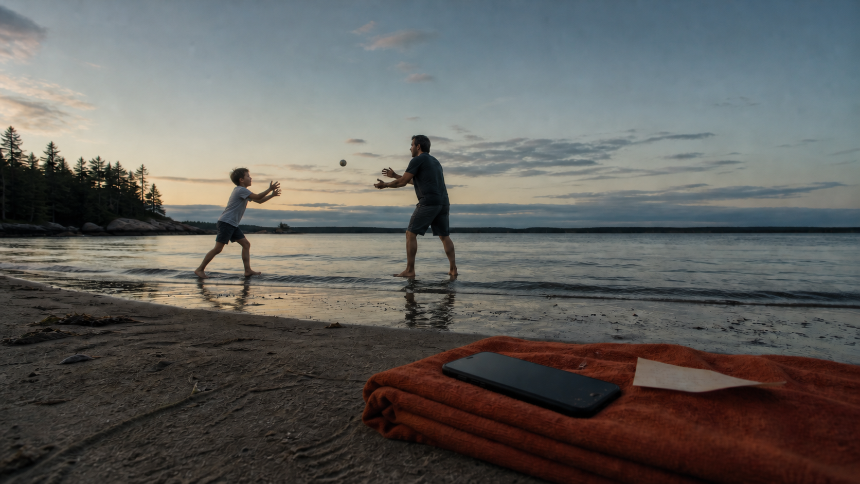 A father and young son play catch at the waterline while a quiet phone rests in the foreground.